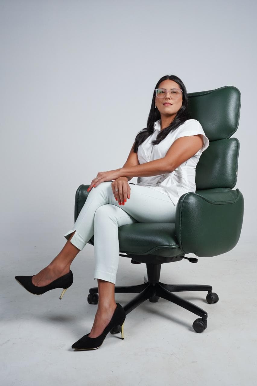 Dra. Victoria A. Gómez sentada em poltrona verde